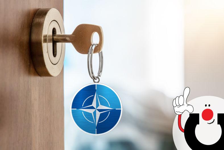 Alaoikealta kurkistava Manuhahmo osoittaa innostuneesti oikeaa kättään ja sormeaan ylöspäin.